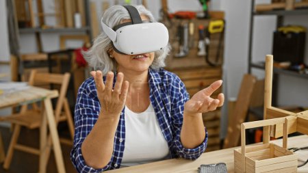 Mujer madura usando auriculares de realidad virtual en taller de carpintería