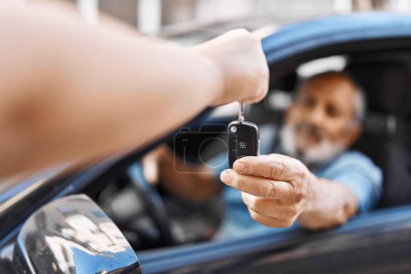 Téléchargez les photos : Senior grey-haired man holding key of new car at street - en image libre de droit