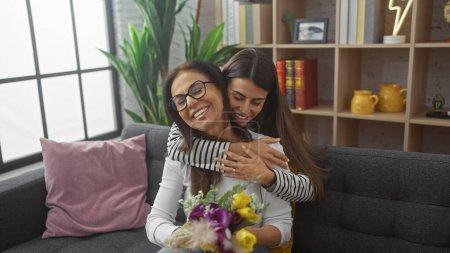 Foto de Un abrazo conmovedor entre una madre y su hija expresando amor y alegría en un acogedor salón con decoración hogareña. - Imagen libre de derechos