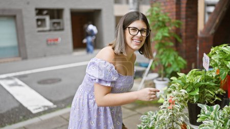 Beautiful hispanic woman, glasses perched, beauteously standing amid colourful flowers on an osaka street, a blooming botanic delight