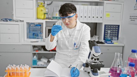 Un científico masculino enfocado analiza un tubo de ensayo en un laboratorio bien equipado, mostrando la investigación y la atención médica.