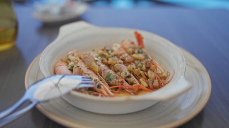 Photo for Close-up of fresh prawns garnished with herbs on a dinner plate, indicative of mediterranean cuisine. - Royalty Free Image