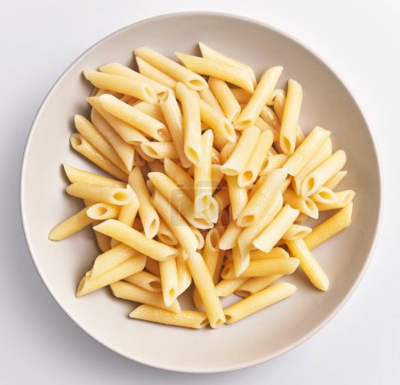 A bowl of cooked penne pasta on a white background, ready for serving or further meal preparation.