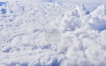 Luftaufnahme einer dichten Baumwollwolkenlandschaft von oben, die die Schönheit natürlicher Himmelsmuster und des Lichts zeigt.