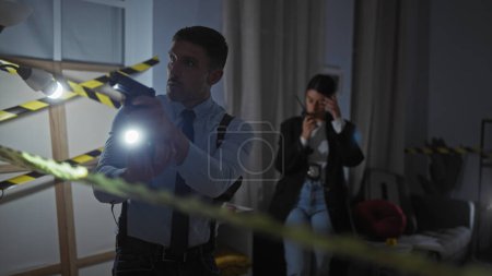 Téléchargez les photos : Une policière et un homme enquêtent sur une scène de crime à l'intérieur, avec une lampe de poche et un ruban adhésif visible. - en image libre de droit