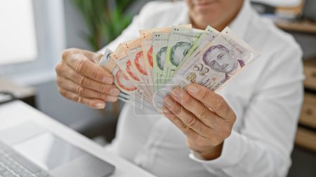 Foto de Un hombre profesional en una oficina muestra la moneda singapurense, mostrando aspectos de negocios, finanzas y economía. - Imagen libre de derechos
