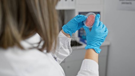 Foto de Científica hispana examina placa petri en laboratorio, retratando temas de investigación y salud. - Imagen libre de derechos