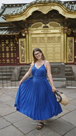 Smiling beautiful hispanic woman in glasses posing confidently at ueno park temple, radiating joy and success