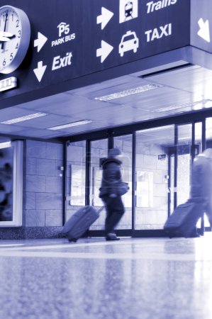 Foto de Salida del aeropuerto con reloj grande, señales de aparcamiento, tren y taxi - Imagen libre de derechos