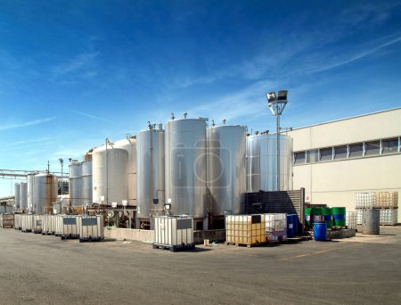 Foto de Exterior de la industria química con silos de acero y recipientes de plástico para líquidos - Imagen libre de derechos