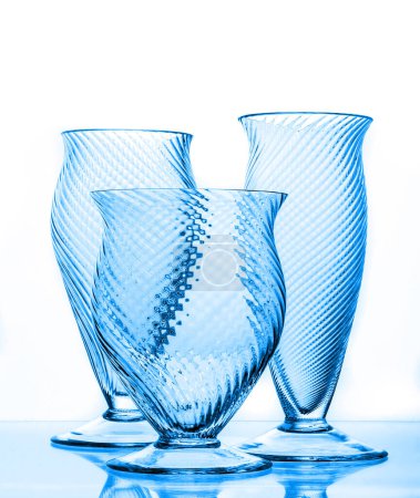 Foto de Tres hermosos vasos en forma de jarrón de cristal azul aislados en blanco - Imagen libre de derechos