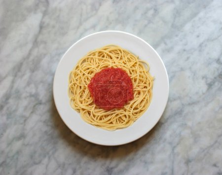 Foto de Plato de espaguetis con salsa de tomate, visto desde arriba en una mesa de mármol - Imagen libre de derechos