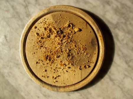 Photo for Round wooden cutting board with bread crumbs on a marble top - Royalty Free Image