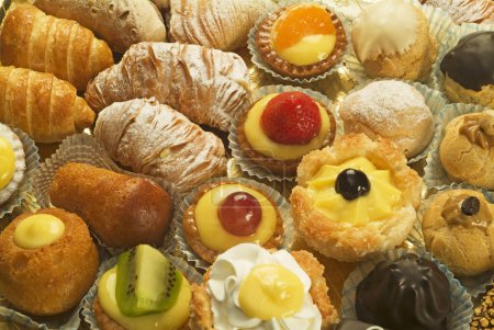 Foto de Mezcla de mini pasteles, incluyendo cannoli, crema y fruta, chocolate, etc. - Imagen libre de derechos