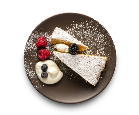 two slices of cake with berries and cream, white background
