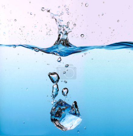 Foto de Cubo de hielo salpicando en el agua azul claro - Imagen libre de derechos