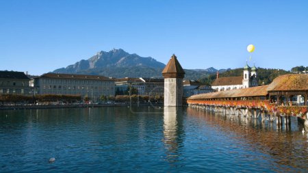Photo for Famous chapel-bridge in Lucerne in Switzerland. The bridge was build in the year 1365, it is the oldest and longest (204 m) bridge with a roof in Europe. Mt Pilatus is on the background - Royalty Free Image