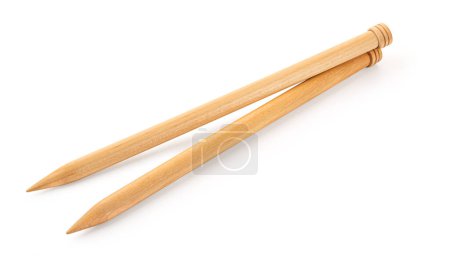 A pair of large wooden knitting needles from low perspective isolated against white background.