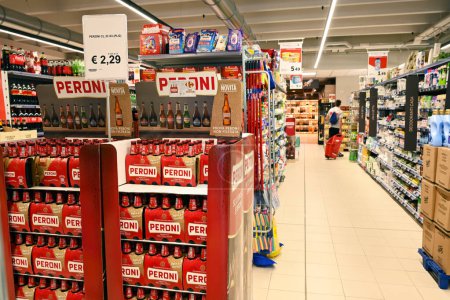 Foto de BARI, ITALIA JULIO 2023: Interior de un supermercado Carrefour. Exhibición de la oferta de cerveza italiana de la marca Peroni en el pasillo de una tienda de comestibles - Imagen libre de derechos