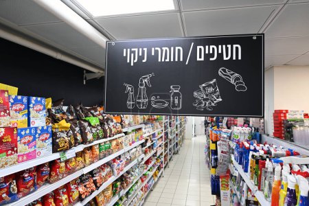 Téléchargez les photos : RA 'ANANA, ISRAEL - MAI 2023 : Snacks et produits de nettoyage, panneau hébreu au-dessus d'une allée de magasin indiquant où se trouvent les marchandises dans un supermarché Mega. - en image libre de droit