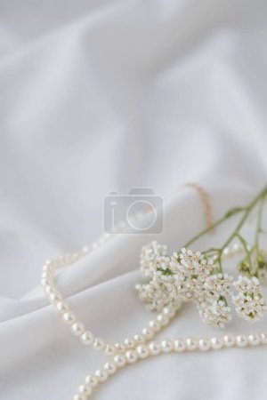 Photo for Pearl necklace on white satin background, closeup of photo - Royalty Free Image