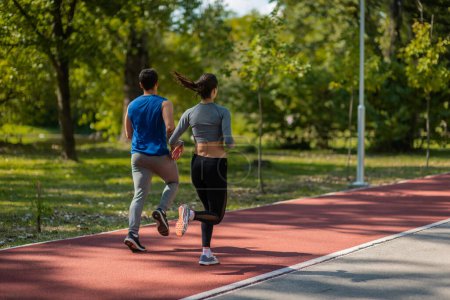 Una pareja deportiva corriendo despacio. Están exhaustos y ralentizaron su ritmo.