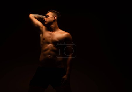 Handsome man posing at the studio shirtless