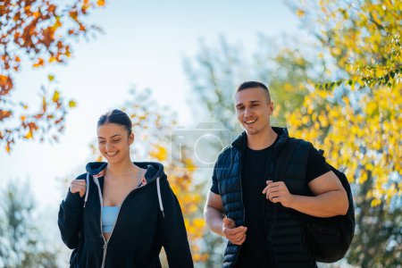 Una foto de cerca de la pareja finess caminar y tener una conversación divertida, en un hermoso día soleado en el parque. Vista frontal