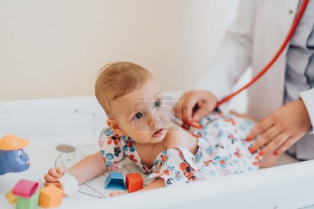 Baby lässt sich im Krankenhaus vom Kinderarzt mit Stethoskop untersuchen