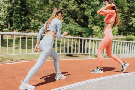 Amigos en forma: Mujeres activas disfrutando del entrenamiento al aire libre en el parque urbano