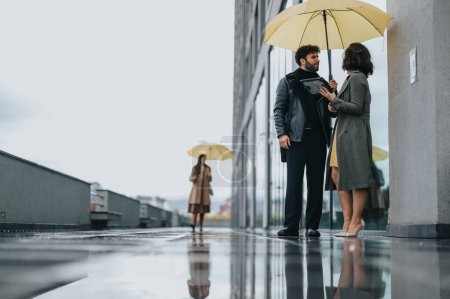 Geschäftskollegen teilen sich an einem regnerischen Stadttag einen Regenschirm mit Spiegelungen.