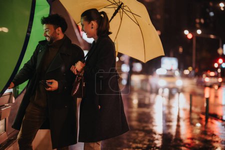Un couple utilisant un distributeur automatique un jour de pluie. L'homme retire de l'argent tout en tenant un parapluie, et ils ont une conversation.