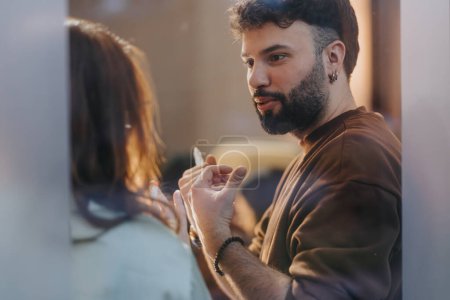 A bearded man with earrings engaging in a casual conversation with an unseen female, conveying a sense of connection and dialogue.