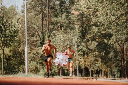 Caucasian Sports Couple Enjoying Outdoor Training with Parachute in Park