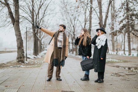 Three young professionals are captured in a candid moment outdoors during a snowy day, discussing work agendas in an urban setting.