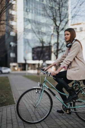 A young female professional rides her bike through city streets, showcasing sustainable transportation in an urban setting.