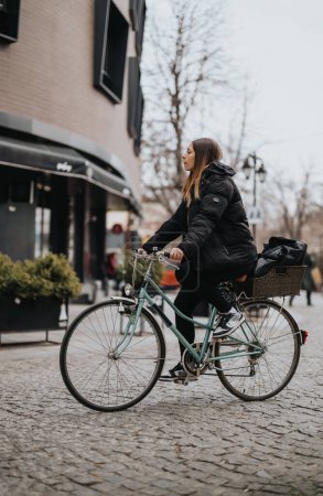 Urban lifestyle scene with a young woman riding a vintage bicycle in the city.