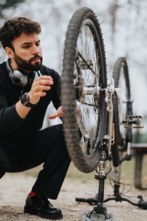 Ein zielstrebiger Geschäftsmann in Freizeitkleidung repariert sein Mountainbike im Freien und demonstriert die Problemlösung.