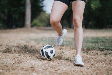 Enjoying a Sunny Day. Attractive Girl Performing Football Freestyling Tricks Outdoors and Exercising Dribbling.