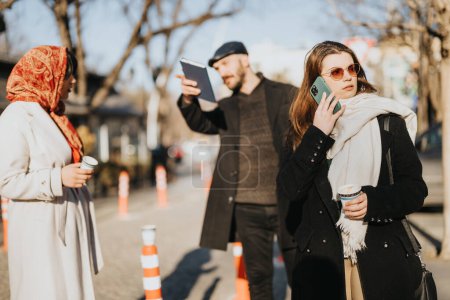 Tres personas diversas en atuendo casual participan en actividades separadas en una acera urbana soleada, que implica el uso de dispositivos móviles y café.