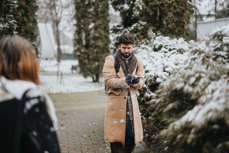 Lässig gekleidete junge Geschäftsleute führen draußen, umgeben von schneebedeckten Bäumen, ein Gespräch, das eine Mischung aus Professionalität und winterlicher Atmosphäre hervorhebt.