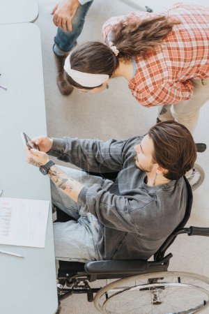 Inclusive workplace portrayed with a tattooed young man in a wheelchair and a female colleague reviewing papers together, highlighting teamwork and accessibility.