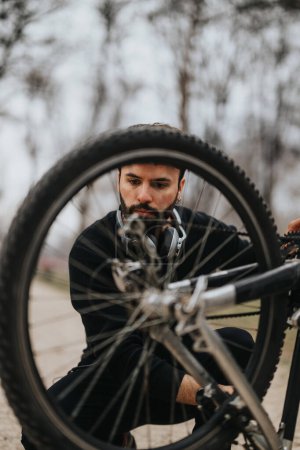 Homme d'affaires concentré en tenue décontractée répare son vélo, dépeignant un mélange de loisirs et une attitude proactive de résolution de problèmes.