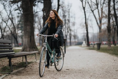 Stilvolle und selbstbewusste junge Frau genießt eine Radtour in einem städtischen Park und steht für einen modernen aktiven Lebensstil.
