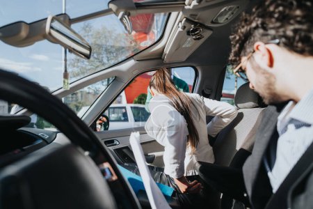 Zwei professionelle Geschäftsleute teilen sich eine Fahrt in einem modernen Fahrzeug, sparen Zeit und fördern die Teamarbeit.