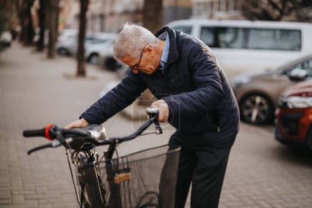 An elderly man securing his bicycle with a lock on an urban street. The image evokes themes of activity, security, and urban lifestyle for seniors.