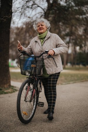 An active senior woman with a bicycle in a park setting exudes health and vitality.
