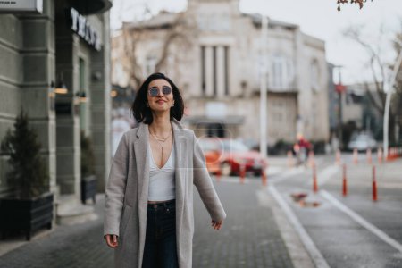 Ein modisches junges Mädchen schlendert an einem Herbsttag durch die Straßen der Stadt und strahlt in ihrer lässigen schicken Kleidung Selbstbewusstsein und Stil aus.