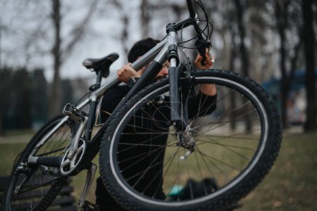 Konzentrierter Geschäftsmann, der eine entspannte Fahrradtour in einer ruhigen Parklandschaft unternimmt und einen aktiven Lebensstil pflegt.