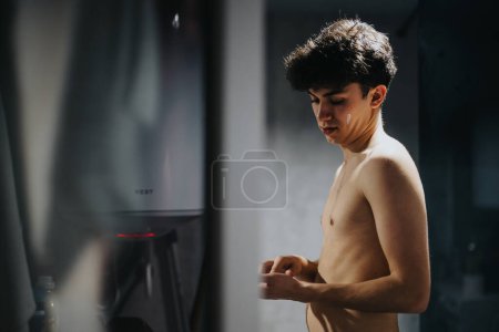 A contemplative young adult standing shirtless, bathed in soft light with a feeling of tranquility and introspection